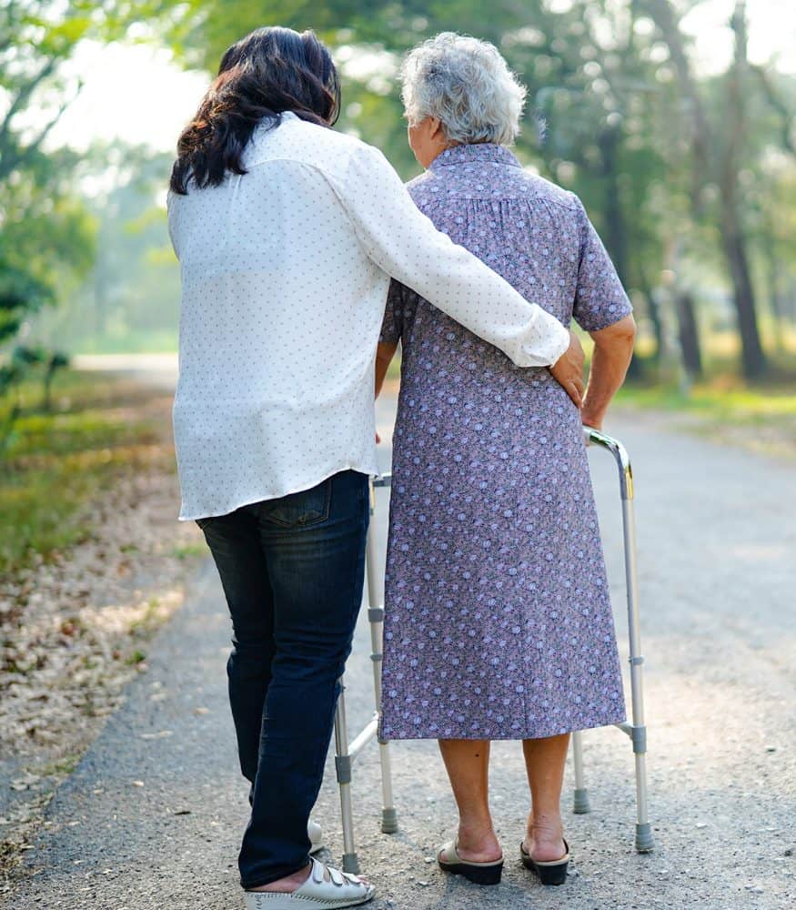 elderly lady-using walker being helped